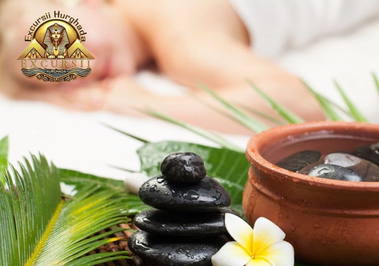 Terapist realizând un masaj de relaxare într-un spa modern, cu lumini calde și uleiuri esențiale.