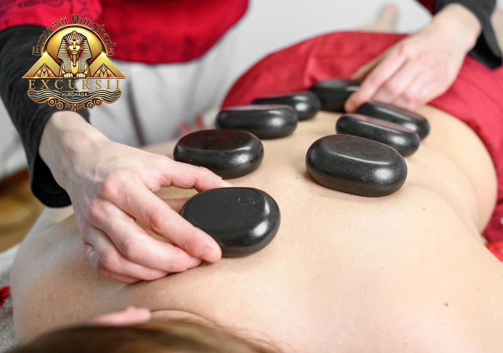 Masaj cu pietre fierbinți aplicat pe spate, pentru relaxare și echilibru, în decor profesional spa.