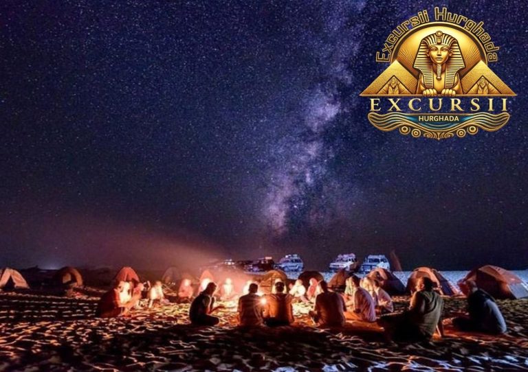 Grup de turiști în jurul focului de tabără în deșert bucurându-se de o excursie inedită de privit stelele sub cerul senin.