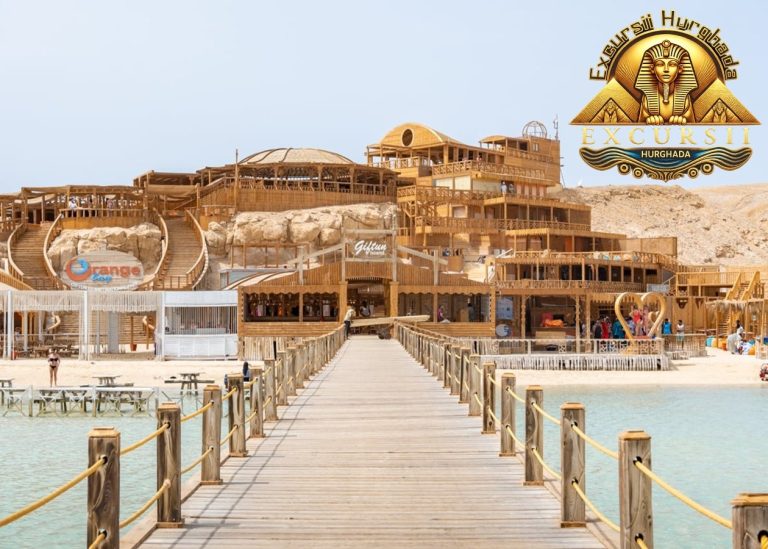 Ponton lung de lemn care duce spre plaja Orange Bay, Insula Giftun, cu structuri rustice și cer senin în fundal.