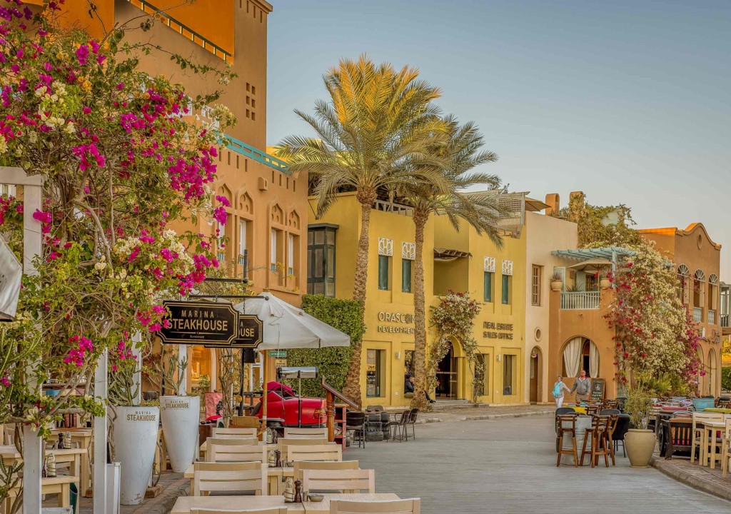 Promenada pietonală din Abu Tig Marina El Gouna cu terase, palmieri și clădiri colorate